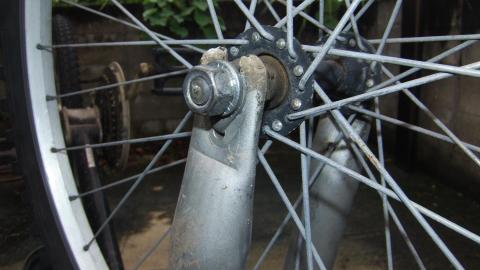 自転車の前輪を止めているパーツを外す