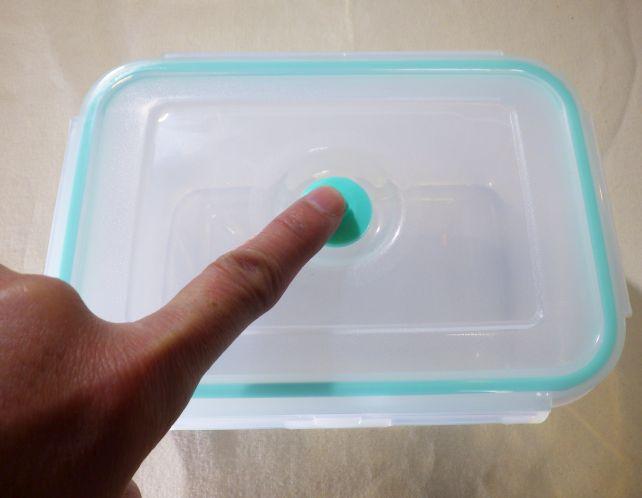 開封時は中央の「へそ」を押して、陰圧を解除する。