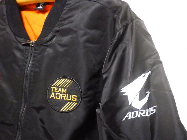 左胸には“”のワッペン、左腕には鷹の頭部を図式化したAORUSのマークの刺繍