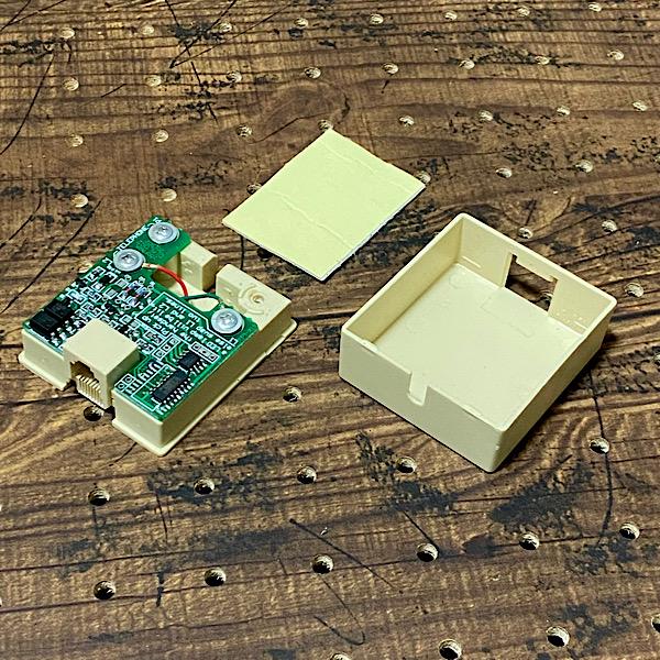 約5cm角の小さなハコです、本体側面にはモジュラーポートが在り反対側には小さな穴(溝)が…