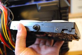 HDD取り付け。ゴム(特大ワッシャーのような感じ)の上から、ビスで留めます