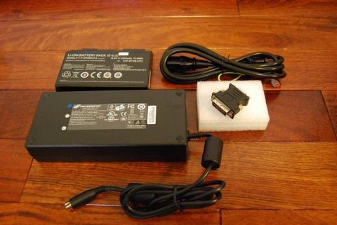 PC付属品。左上から時計回りでバッテリー、電源ケーブル、映像変換端子、電源アダプター。電源ケーブルと電源アダプターをくっつけると1200gになります。