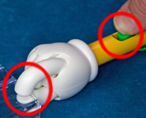 指先の間に物を挟み、ボタンを押し込んだところ