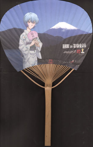 字面のうちわを持って立つレイ