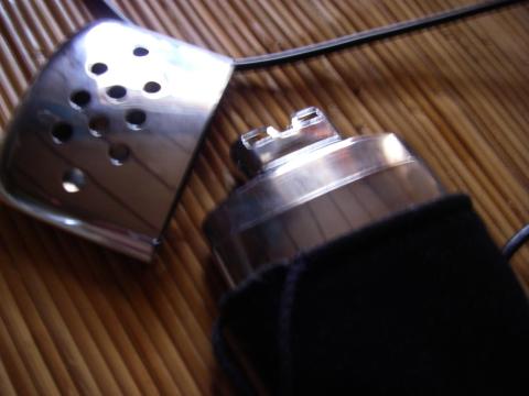 反応完了。フリース袋に入ってる方の小さな部品が火口です。穴の開いているステンレス部品の方がキャップです。