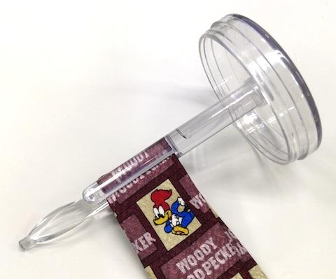 ネクタイの折り目部分をフタの芯棒(クリップの内側)に通します。