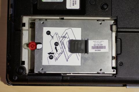 赤丸のねじを緩め、黒いベロを上に引っ張りながら左にスライドさせるとHDDが外れます。