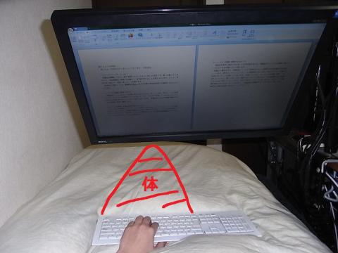 ベッドでアームに吊られたモニターを見ている図